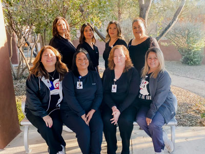 Picture of Home Health and Hospice staff. There is eight smiling females outside in a group picture.