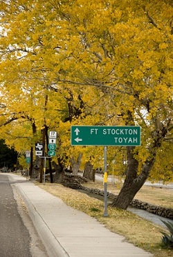 This is a picture of an road sign saying FT Stockton straight and Toyah turn left.